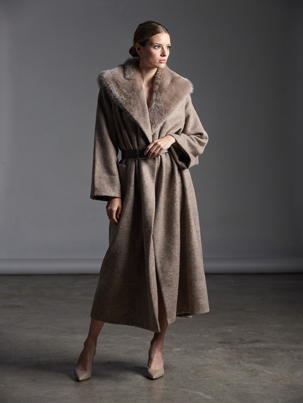 Herline Studio model presenting seasonal capsule outerwear and dress in studio light